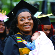 Woman in cap and gown holding baby